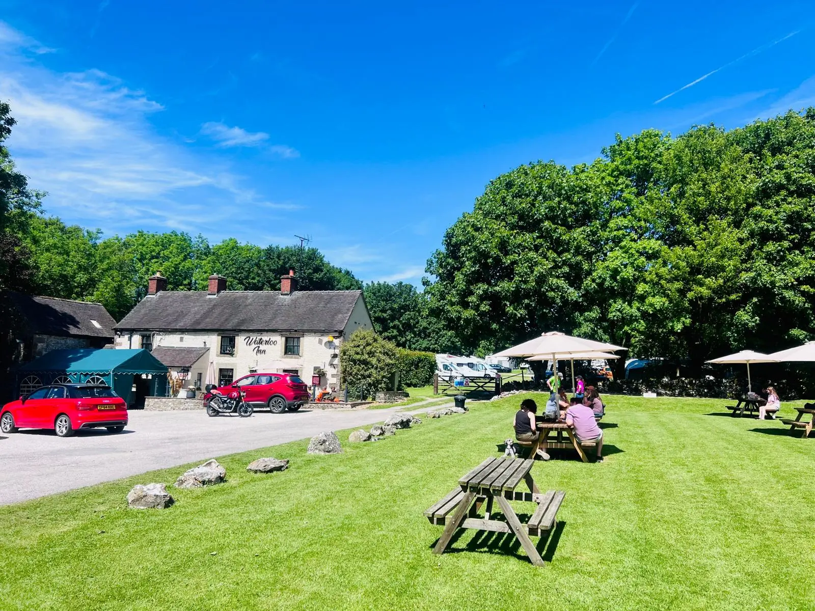 Sunny beer garden at The Waterloo Inn with picnic benches and countryside views